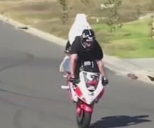 Stunt rider rolling stoppie