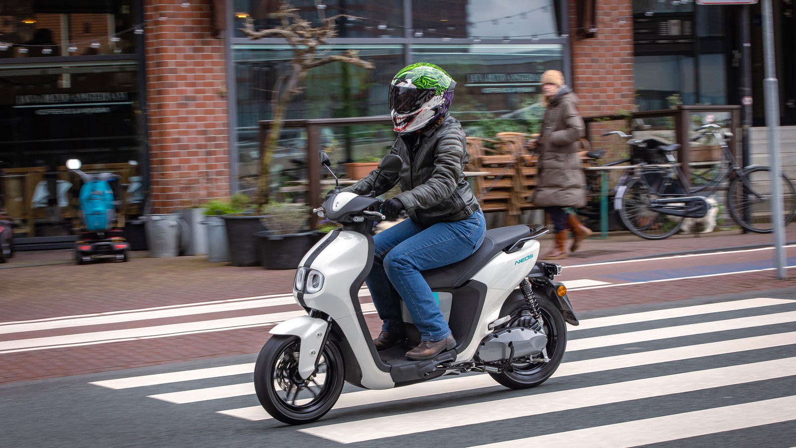 Yamaha NEO's riding through an urban area. Ride wearing blue riding jeans and black, leather riding jacket and Joker Ruroc ATLAS 4.0 helmet.