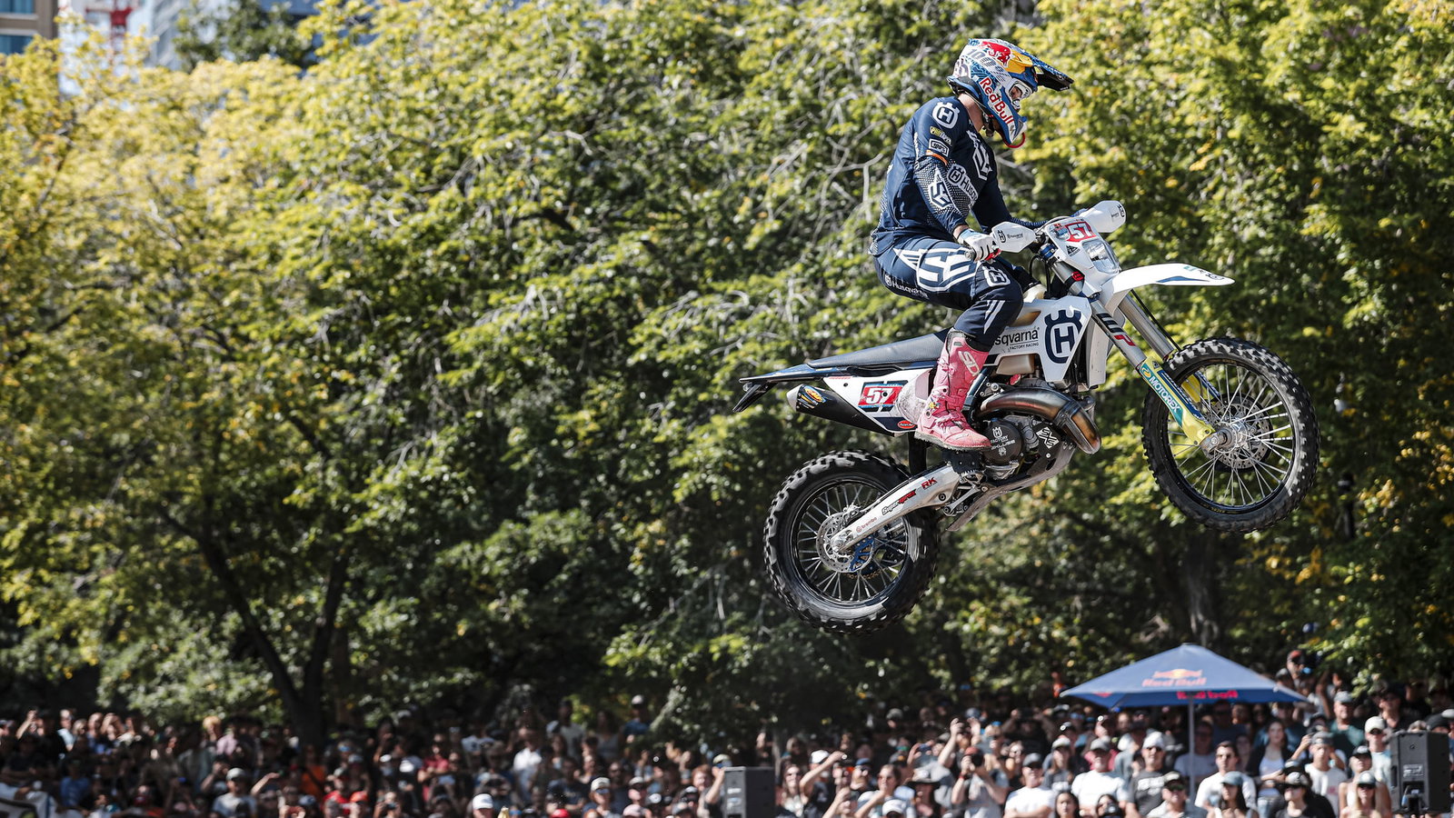 Billy Bolt jumps his Husqvarna enduro bike past a crowd of fans. - Red Bull Content Pool.