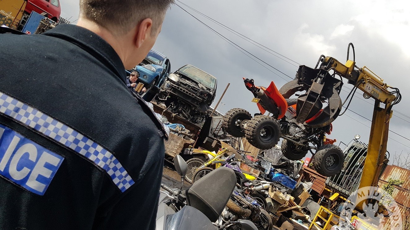 A Police officer watching nuisance motorcycles and quad bikes being crushed