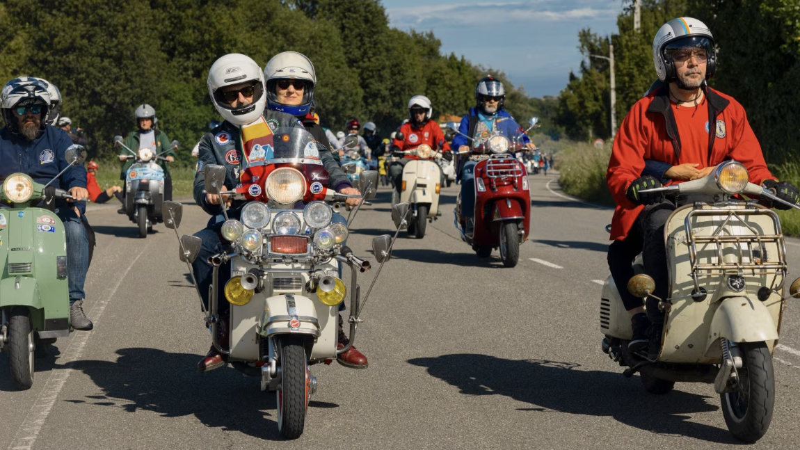 Vespa scooters on the road at World Days event. Credit - Vespa