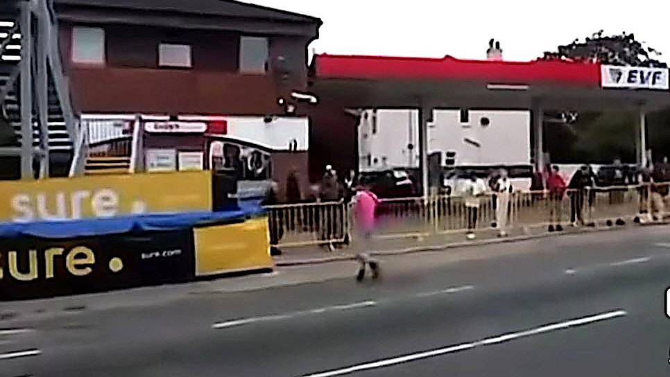 A man crosses the lice TT course during a race