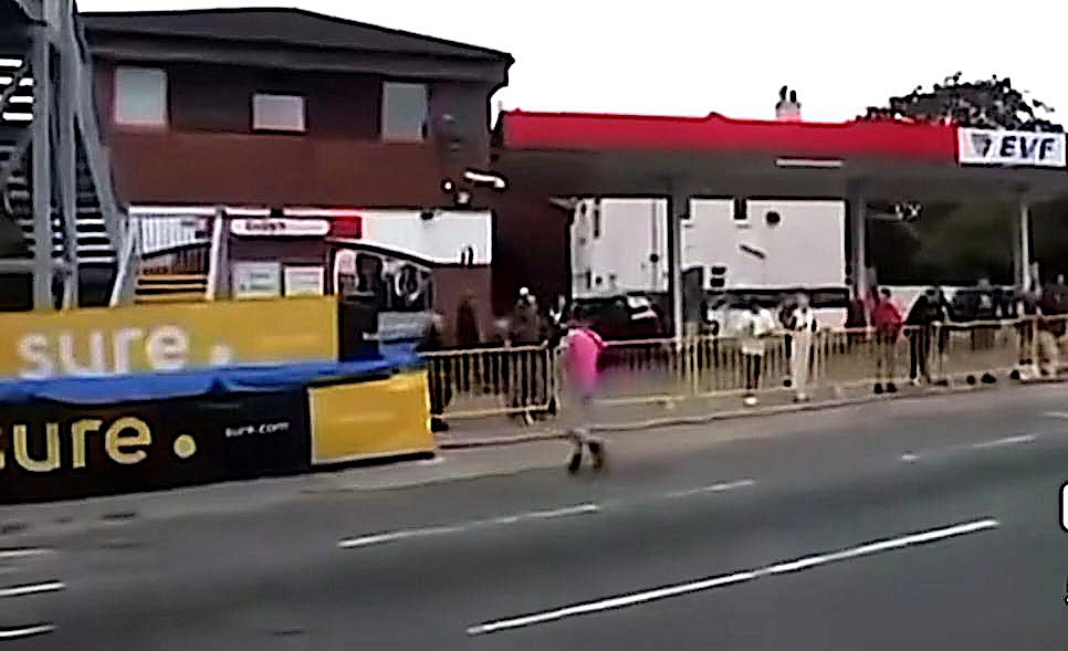 A man crosses the lice TT course during a race