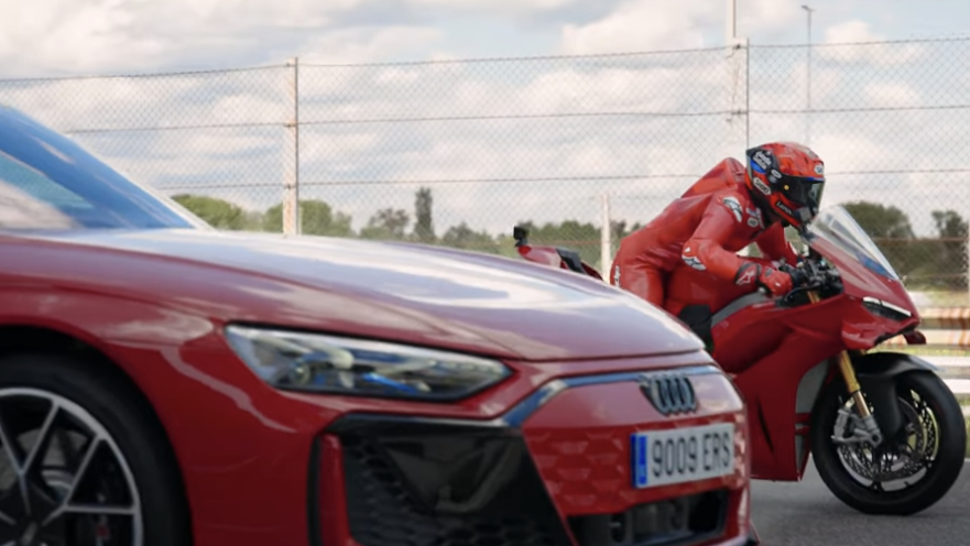 Marc Marquez lining up against an Audi on his Ducati Panigale V4 S