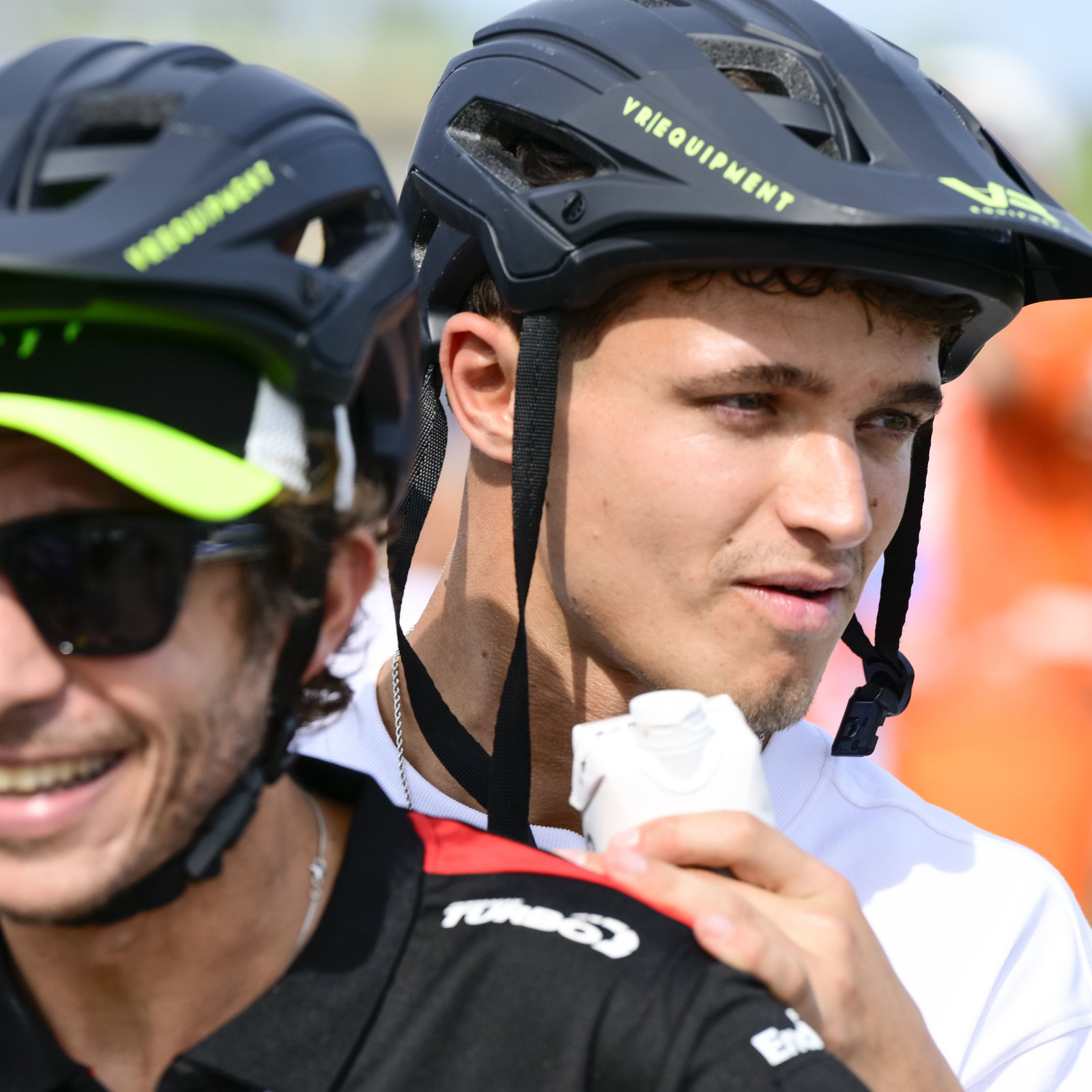 Lando Norris on the back of a scooter ridden by Valentino Rossi