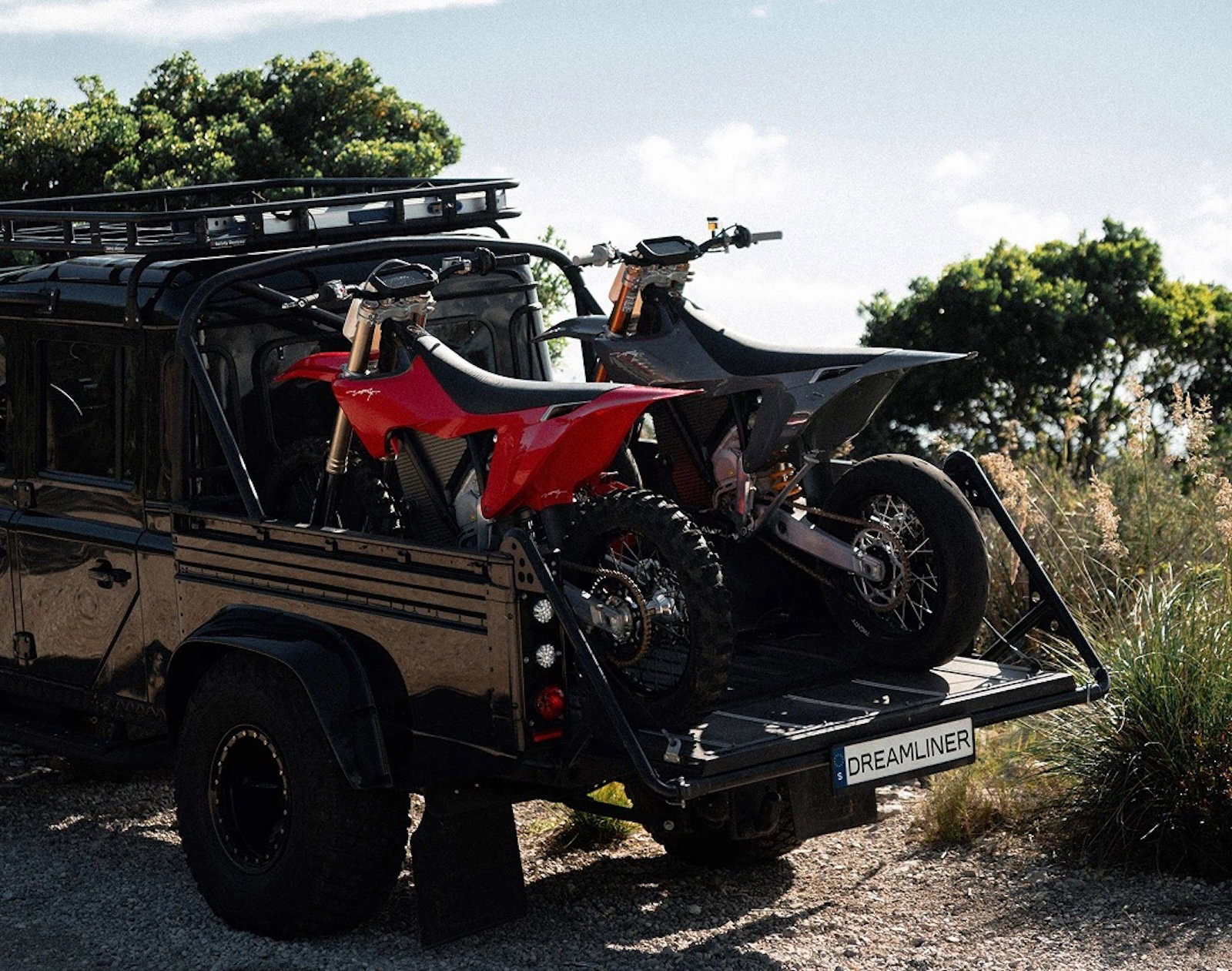 Two Stark Varg dirt bikes in the back of a pick-up Land Rover