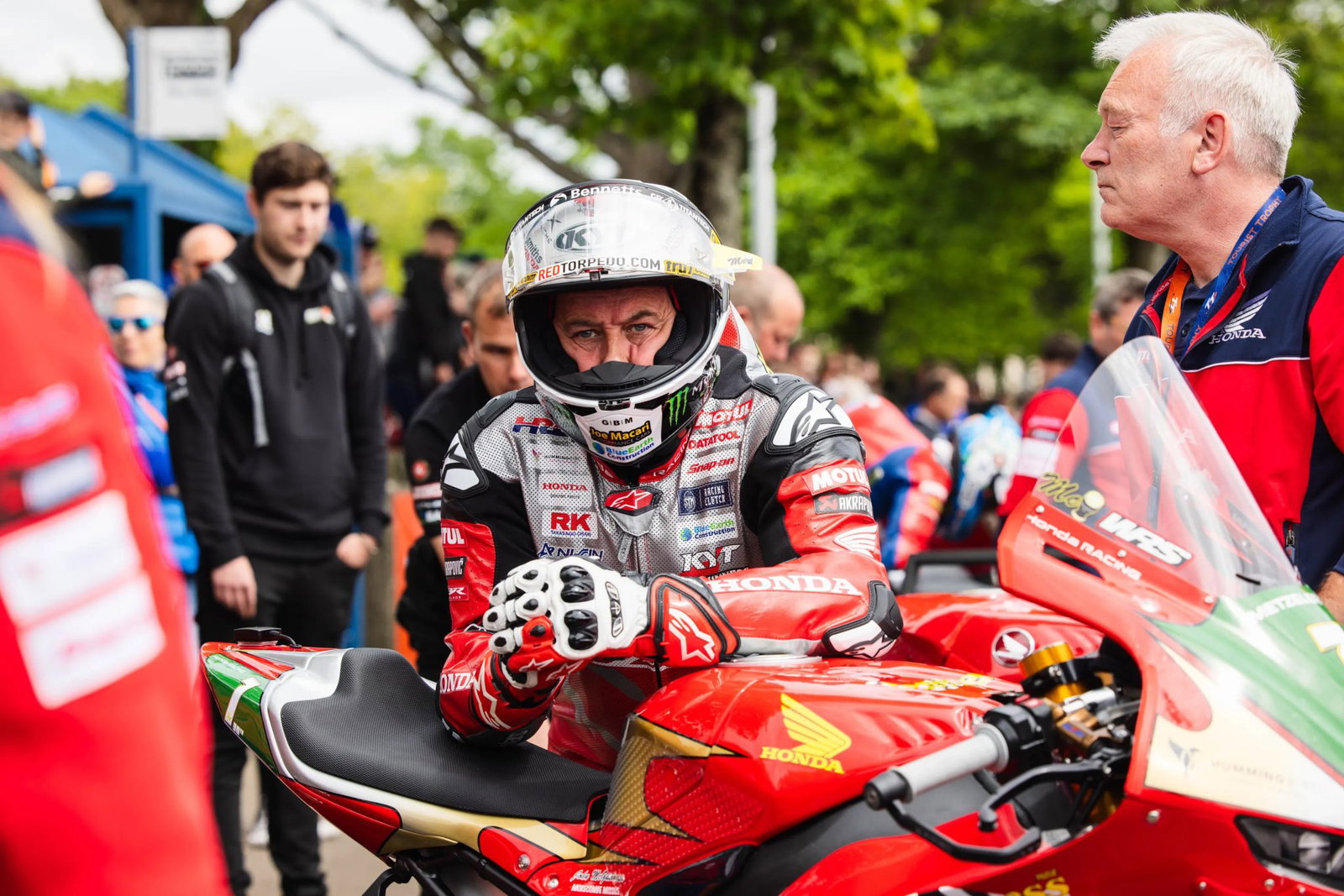 John McGuinness leaning on his Honda Superbike before a TT race