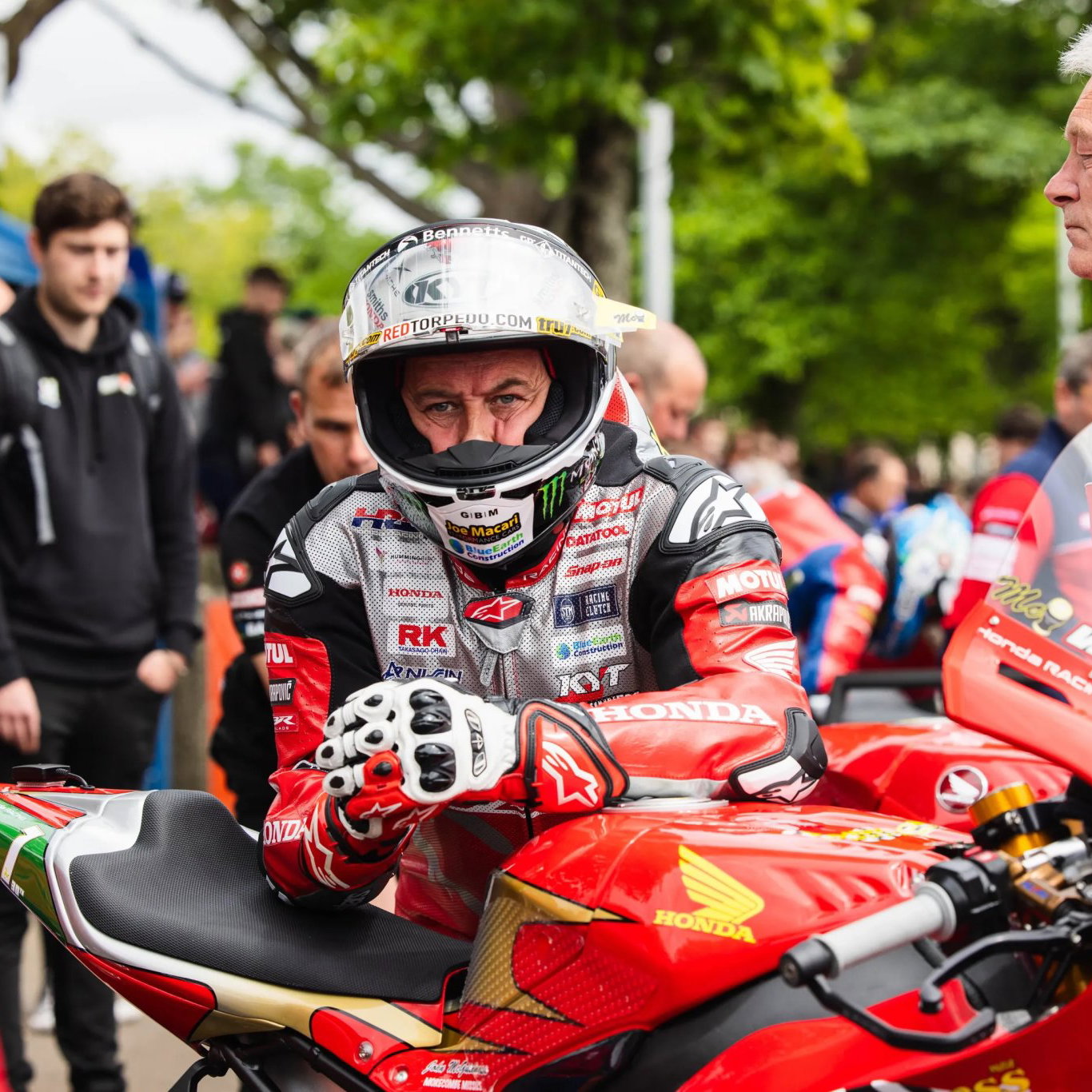 John McGuinness leaning on his Honda Superbike before a TT race