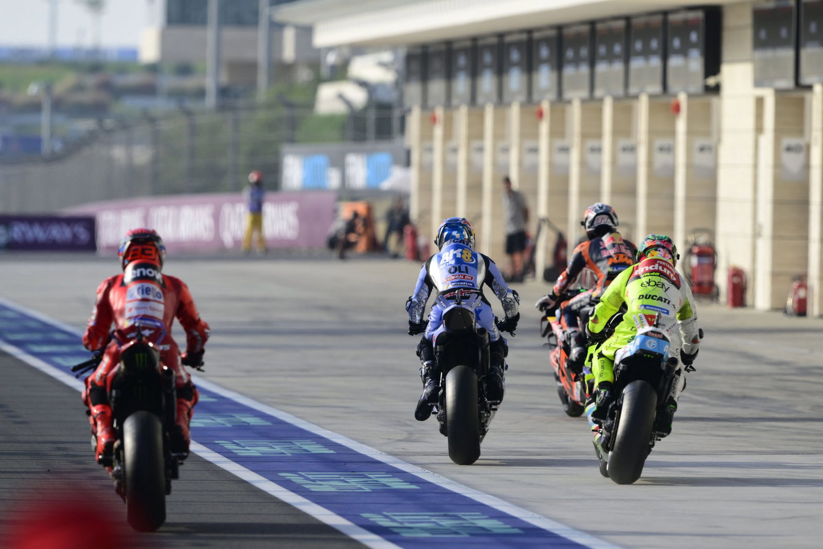 MotoGP bikes riding down pit lane in Qatar. Credit: Gold and Goose.