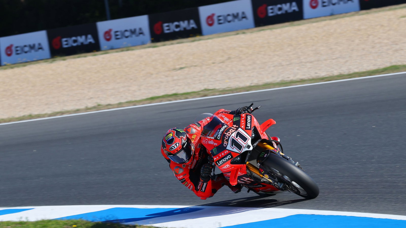 Nicolo Bulega rides a Ducati WorldSBK machine while EICMA branding features behind him.