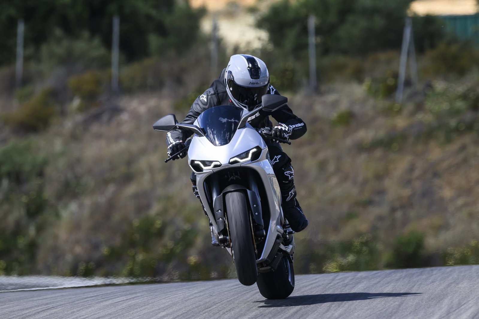 A Norton Manx R cresting a rise on track