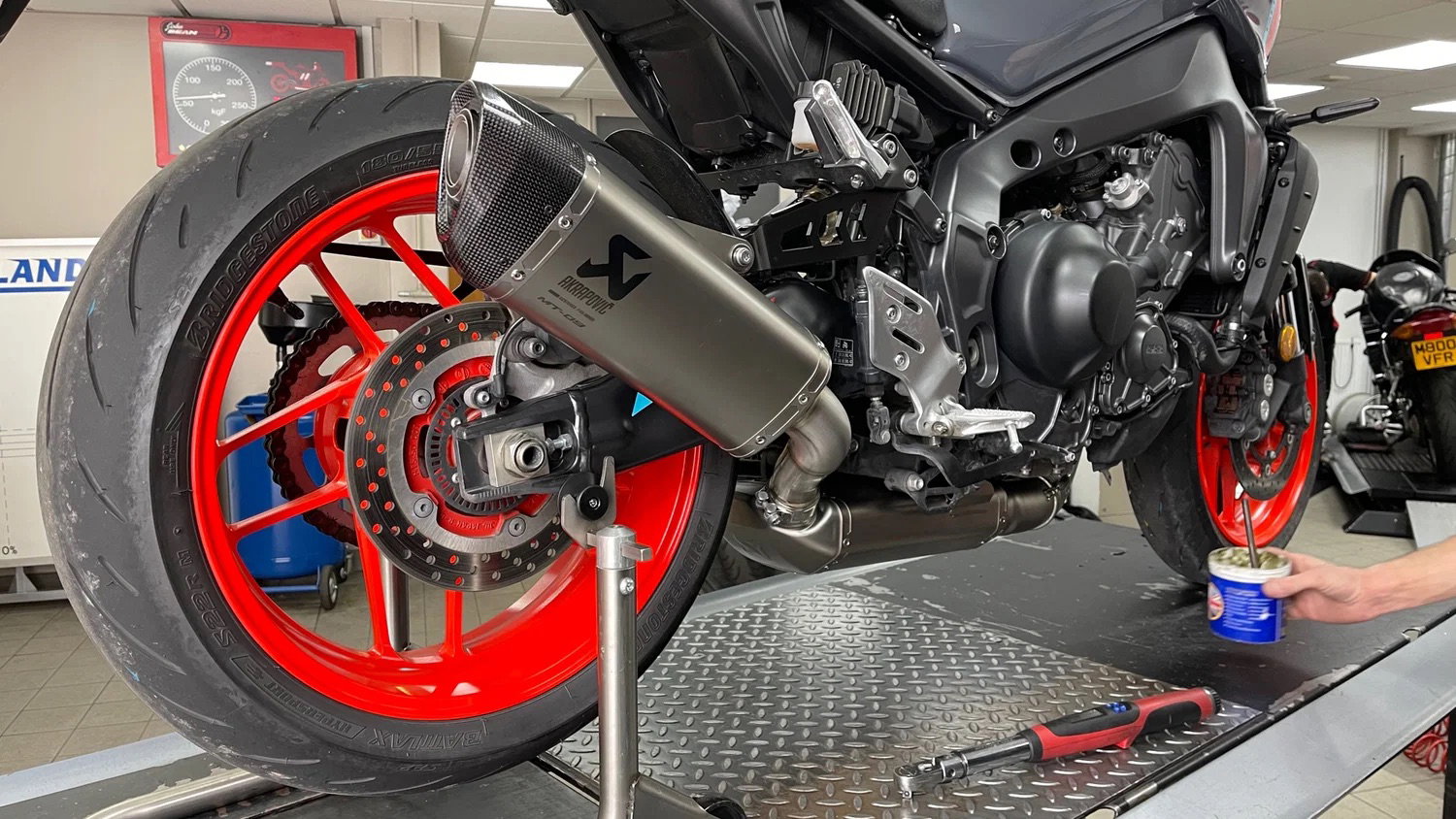An Akrapovic exhaust being fitted to a bike