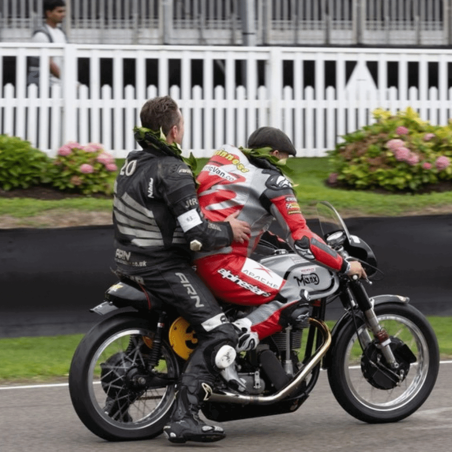 John McGuinness riding a Norton with a passenger.
