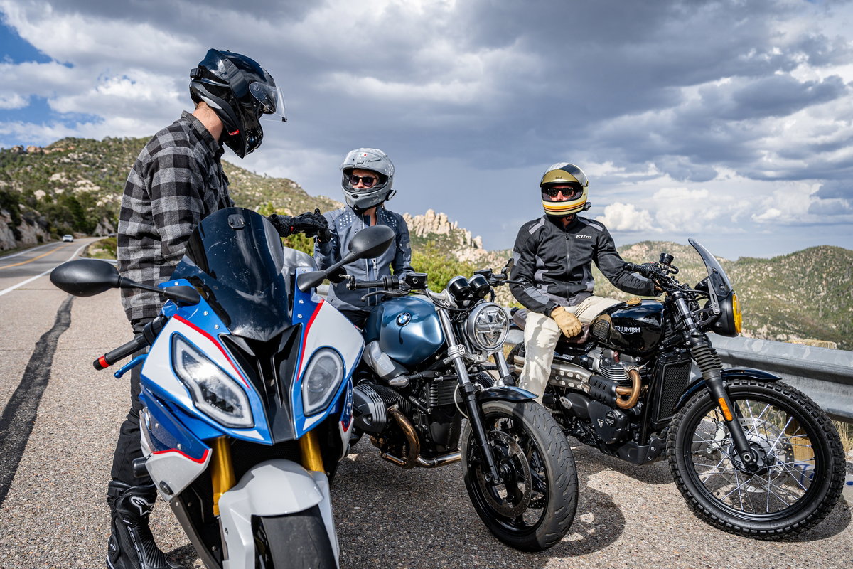 Motorcyclists parked at the side of a road.