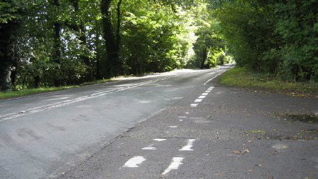 A272 passes between trees. - Sabre Roads