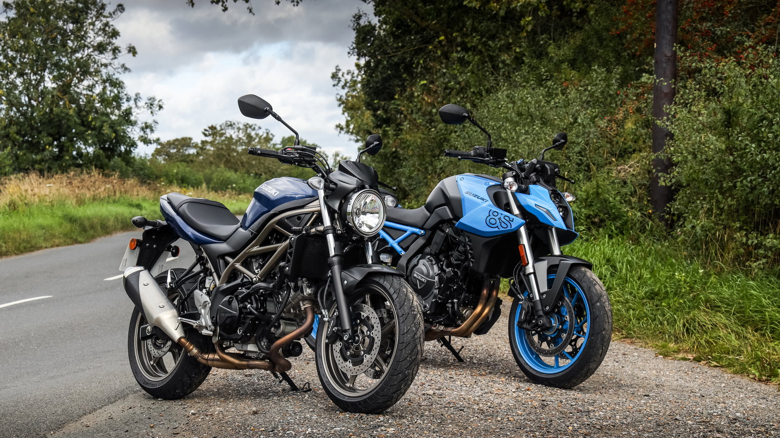 Two motorcycles parked at the side of the road