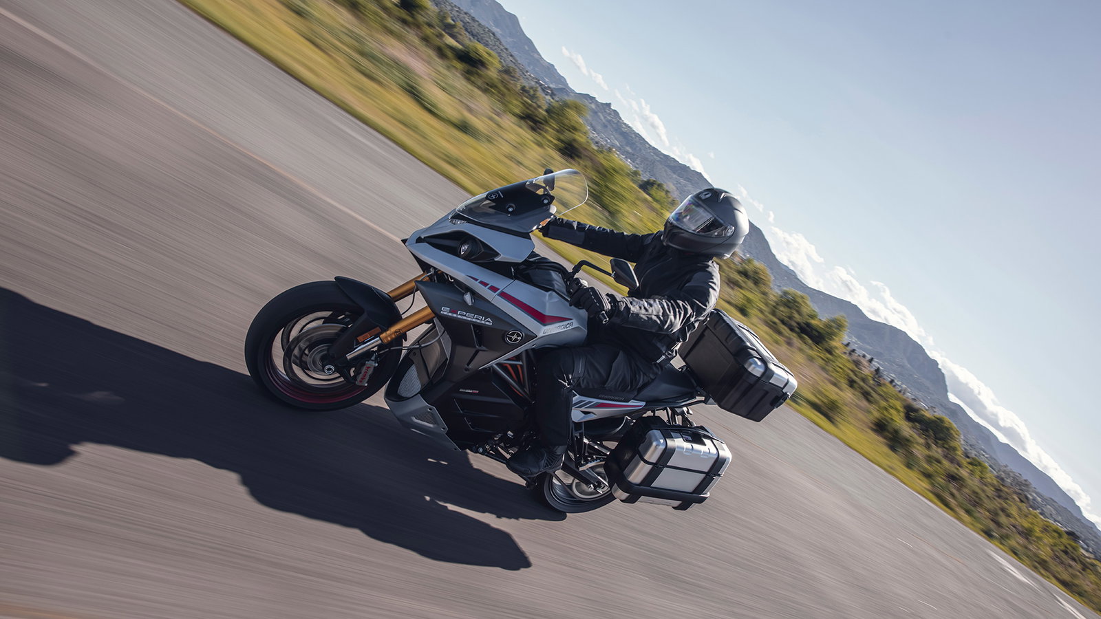 Experia electric sports touring motorcycle ridden on a scenic road