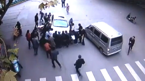Video: Passers-by lift car off woman after being knocked off scooter