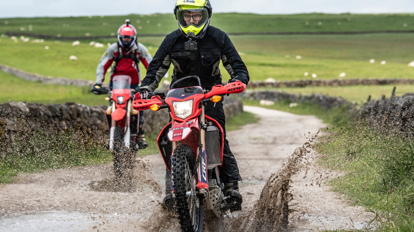 Two trail bikes on a green lane