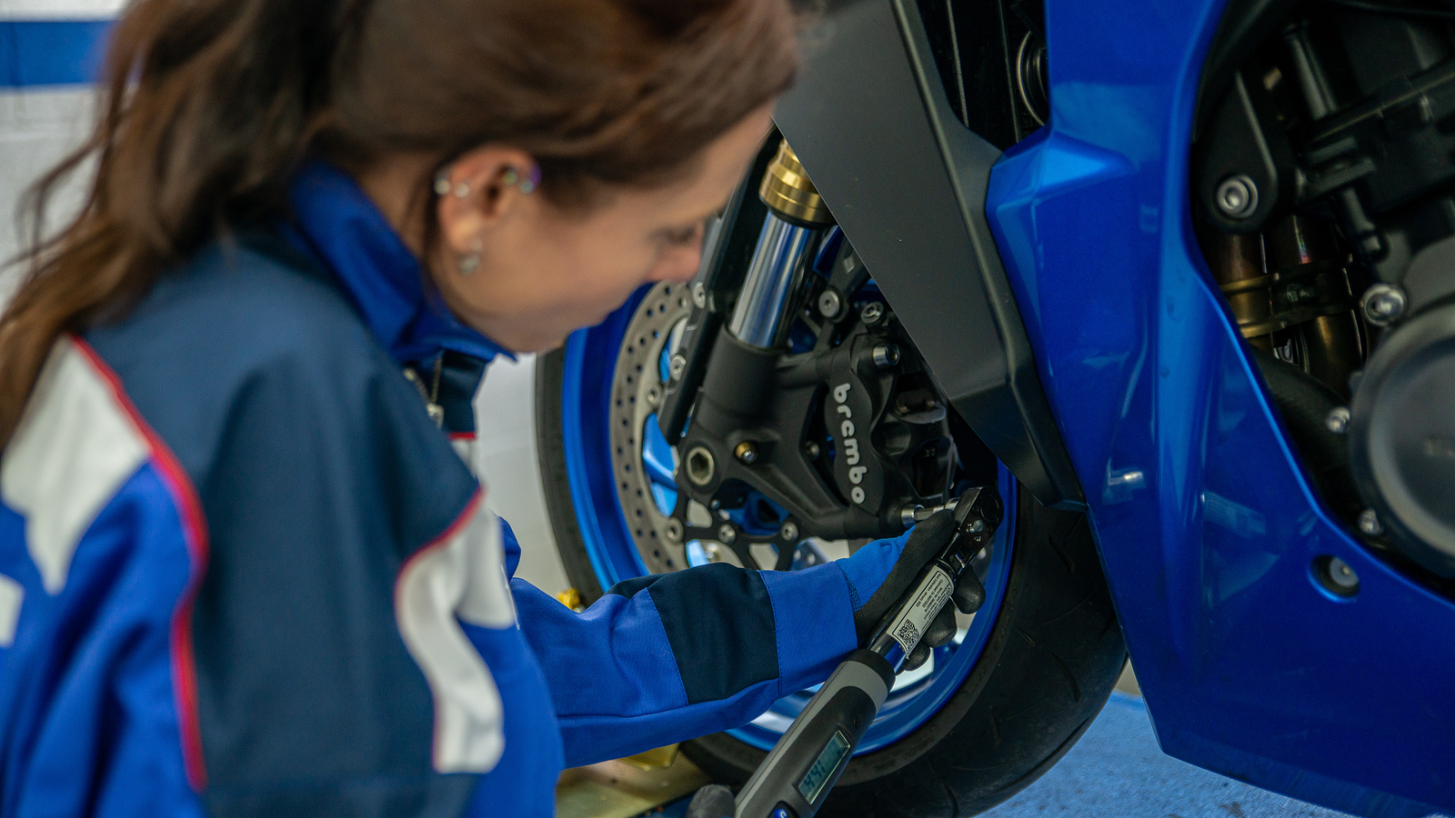 Mechanic servicing Suzuki motorcycle. - Suzuki